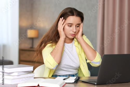 Young student having stress before exam at desk