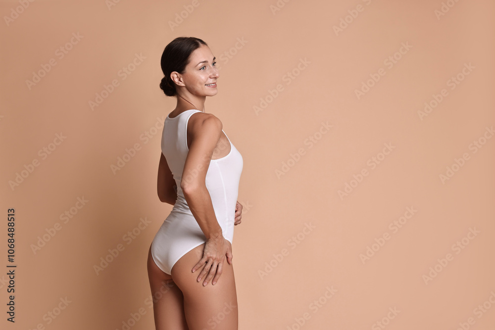 Smiling woman with perfect skin posing on beige background, space for text. Body care Smiling woman with perfect skin posing on beige background, space for text. Body care