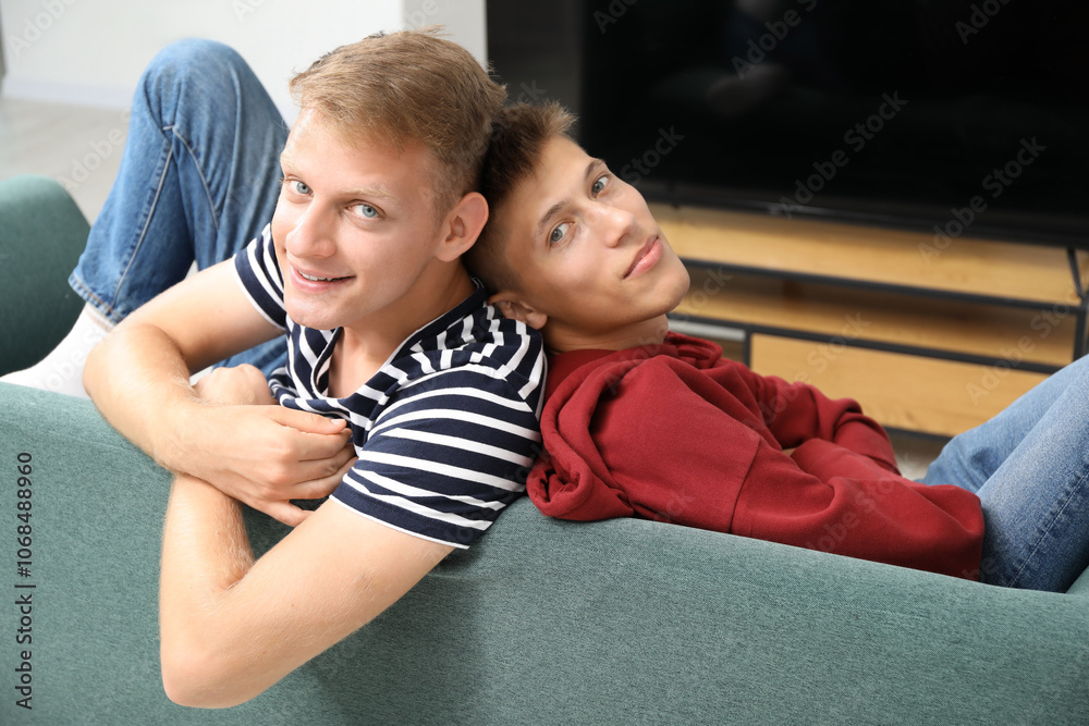 Obraz premium Family portrait of happy brothers on sofa at home