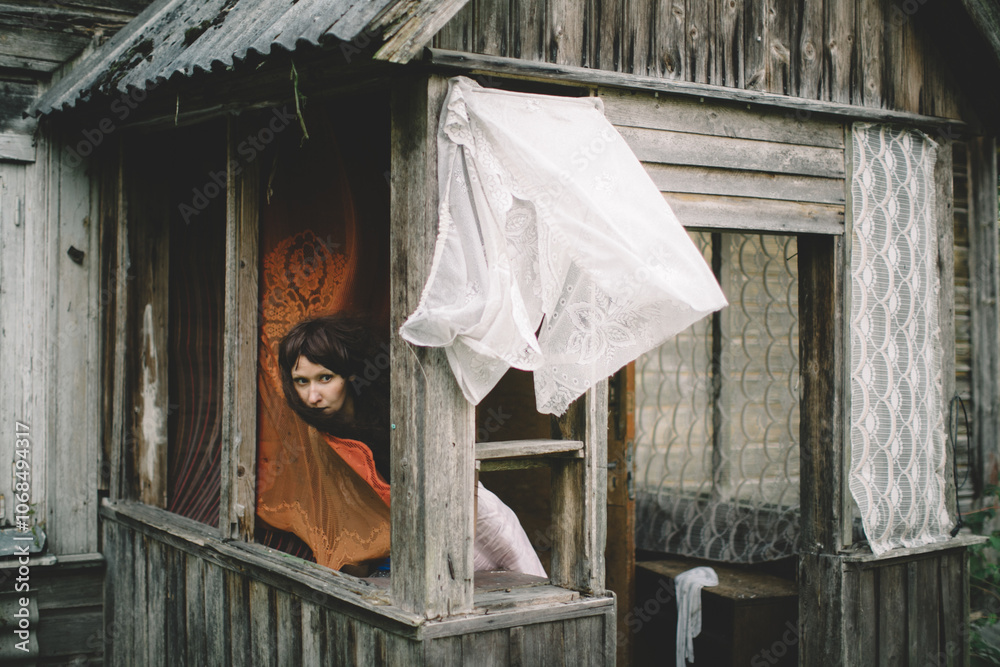 Curious Woman Peeking Through Rustic Cabin Window Curious Woman Peeking Through Rustic Cabin Window