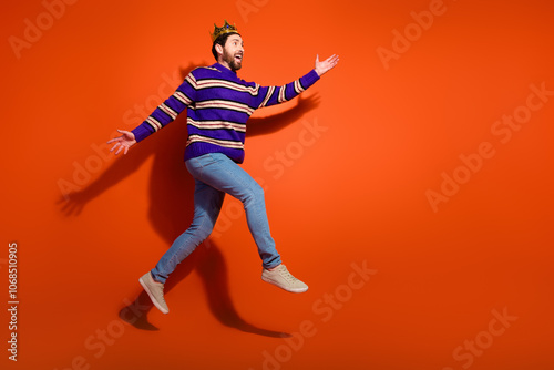 Full length photo of handsome young guy running excited fast dressed stylish striped purple garment isolated on orange color background