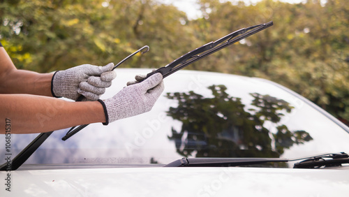mechanic is checking car wiper blades to replace new wiper blades for car during the rainy season because when it rains it can be used at full efficiency. Checking and cleaning the car wiper blades