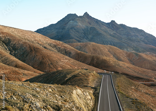 Beautiful panoramic view on colorful remote basal hills, empty road and mountains of Massif of Betancuria as seen from observation point, Fuerteventura, Canary islands, Spain, travel destination photo