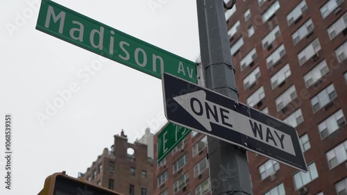 A street sign positioned at the bustling intersection of Madison Avenue and East 79th Street within a city layout