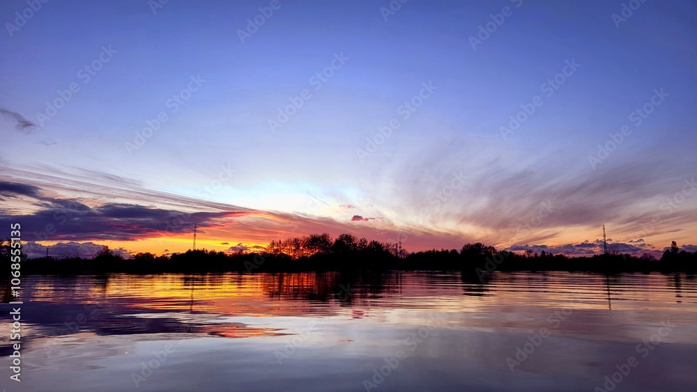 Beautiful sunset on the lake in lilac and pink tones, golden evening sun Beautiful sunset on the lake in lilac and pink tones, golden evening sun