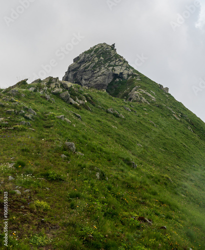 Foto MOuntain ridge with steep slopes covered by grass and rocky hill summit in Alpi