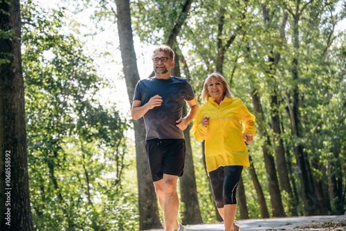 Front view, jogging, sports. Senior couple together outdoors at nature