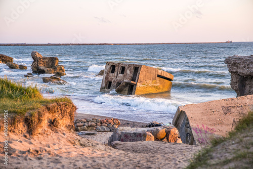 Fototapeta Naklejka Na Ścianę i Meble -  Liepaja beach bunker. Abandoned military ruins facilities in a stormy sea. Barracks building in the Baltic sea. Liepaja, Latvia.