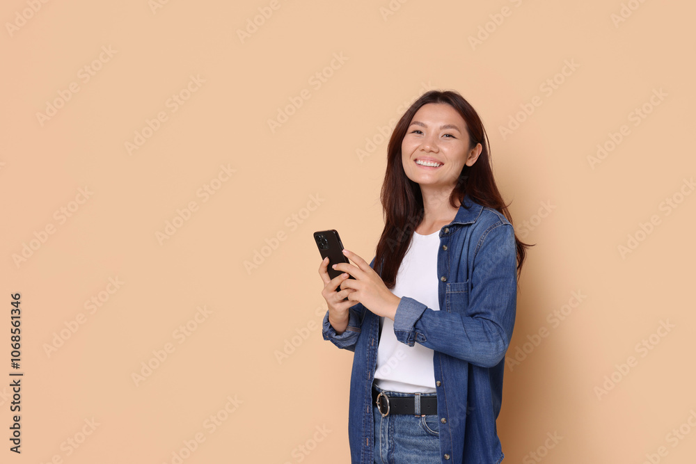 Smiling woman with smartphone on beige background. Space for text Smiling woman with smartphone on beige background. Space for text