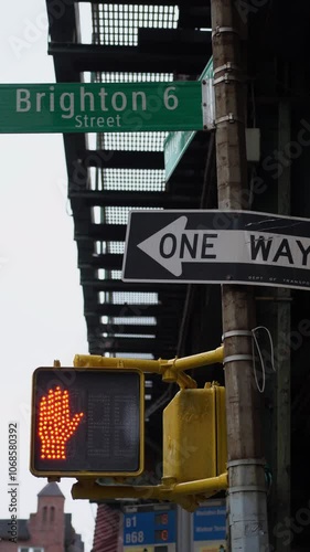 A lively Brighton street scene features traffic signals, directional signs, and bustling activity everywhere
