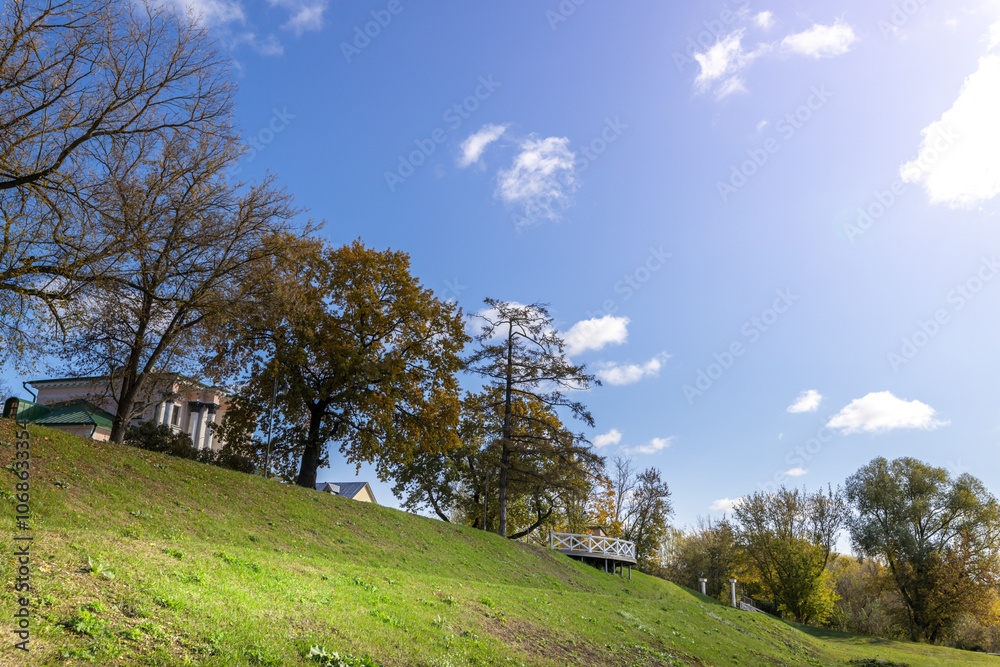 A hillside with a house and trees in the background