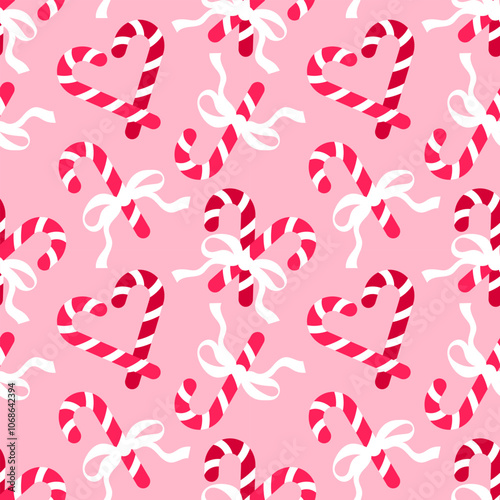 Seamless pattern with Christmas candy canes and bows on pink background. Romantic background design for fabric, wrapping paper, textile, wallpaper