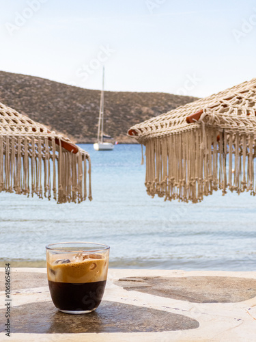 Greek Freddo Espresso under a woven umbrella on Vathi Beach, Sifnos Island 