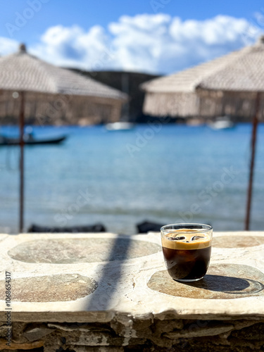 Greek Freddo Espresso under a woven umbrella on Vathi Beach, Sifnos Island  photo