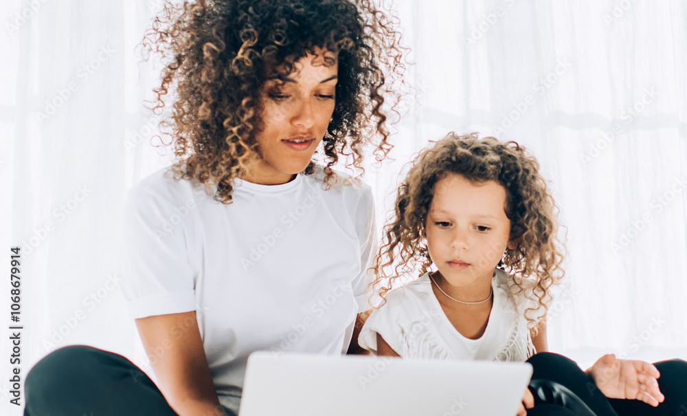 Focused mother and daughter browsing on laptop Focused mother and daughter browsing on laptop