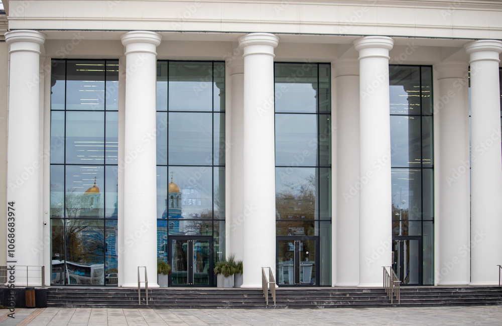 The building has four pillars and a large glass window The building has four pillars and a large glass window