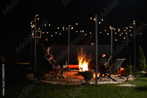Foto Cozy outdoor evening with fire pit and string lights