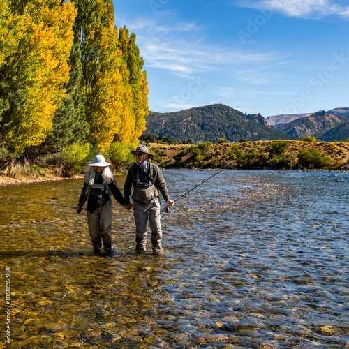 Rear view of senior couple flyfishers wading in Traful River photo