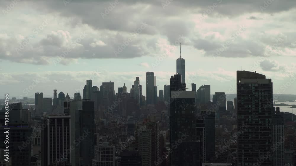 A breathtakingly stunning view of an urban city skyline filled with towering skyscrapers under a moody, overcast sky. New York Manhattan. A breathtakingly stunning view of an urban city skyline filled with towering skyscrapers under a moody, overcast sky. New York Manhattan.