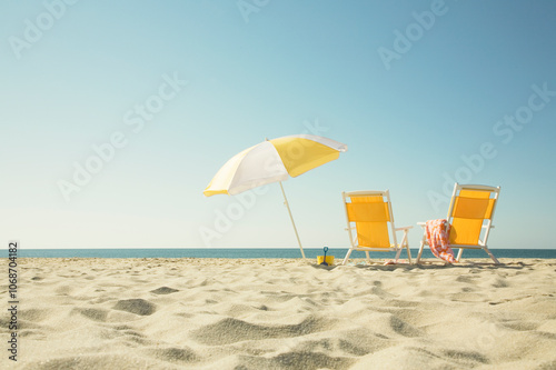 USA, Massachusetts, Nantucket, Two yellow beach chairs and umbrella on sandy beach facing ocean