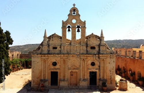 Beautiful historic monastery stands illuminated by the midday sun in Greece, its elegant architecture showcasing intricate details from centuries past. The stone building glows warmly in the sunlight. photo