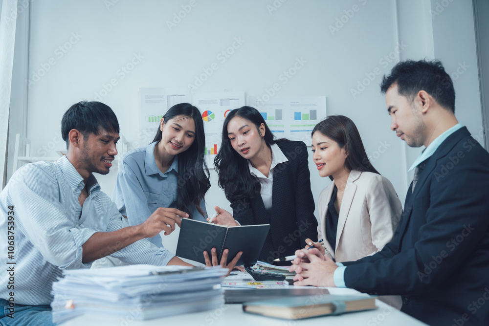 Business Team Collaborating: A group of diverse professionals in suits and business attire gather around a table to review data. Business Team Collaborating: A group of diverse professionals in suits and business attire gather around a table to review data.