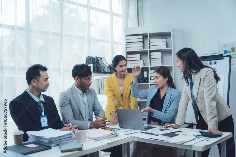 Business Meeting Collaboration: A diverse team of professionals, dressed in business attire, huddle around a laptop, engaged in a lively discussion. Business Meeting Collaboration: A diverse team of professionals, dressed in business attire, huddle around a laptop, engaged in a lively discussion.