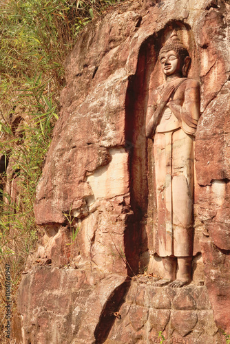 A Sandstone Buddha Rock Sculpture carved into the rock along the road on the Thakhek Motorbike Loop, Laos photo