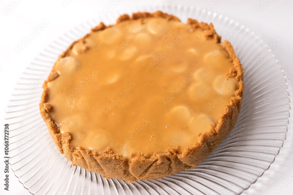 Banoffee banana pie with caramel sauce on the white background. Traditional english cake. Ready to eat. Cooking concept Banoffee banana pie with caramel sauce on the white background. Traditional english cake. Ready to eat. Cooking concept