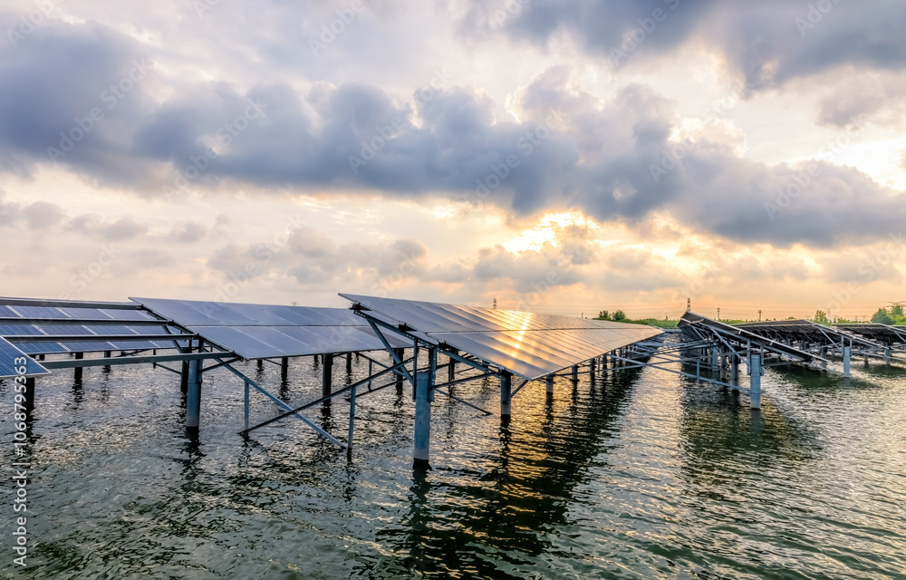 Fototapeta premium Solar panels on river and cloudscape at sunset
