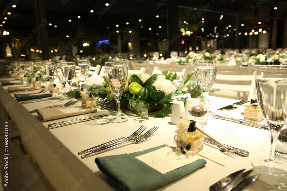 An intimate and elegant dinner setting with a long table and soft lighting. The table is decorated with simple yet sophisticated details