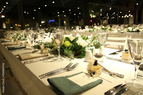 An intimate and elegant dinner setting with a long table and soft lighting. The table is decorated with simple yet sophisticated details