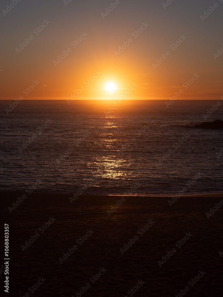 Sun on the horizon at sunset, over the ocean. Beautiful vertical background with dramatic colors. Sun on the horizon at sunset, over the ocean. Beautiful vertical background with dramatic colors.