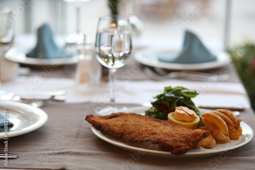 Obraz na płótnie Crispy Wiener Schnitzel with Lemon, Served with Fries and Salad, Classic Austrian Dish, Comfort Food w salonie