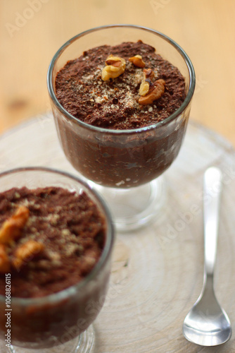 Two bowls of chia seed, chocolate and orange pudding. Healthy snack, wooden background. Selective focus.