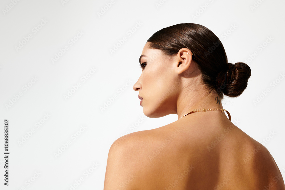 A young woman turns her head slightly, presenting a graceful profile and a chic hairstyle A young woman turns her head slightly, presenting a graceful profile and a chic hairstyle