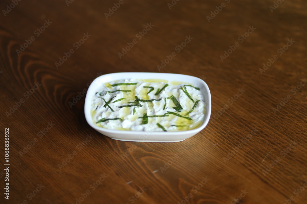 A refreshing and creamy Turkish yogurt dip, topped with fresh herbs and olive oil