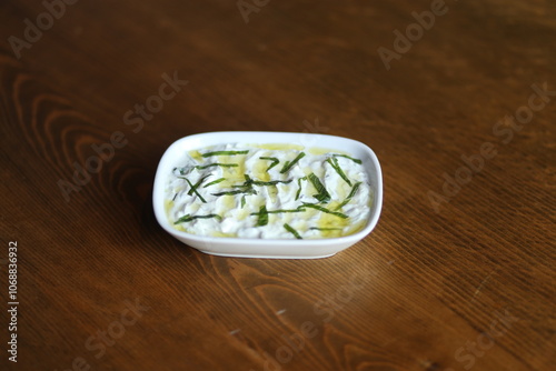 Obraz na płótnie A refreshing and creamy Turkish yogurt dip, topped with fresh herbs and olive oil w salonie