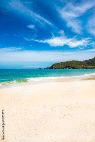 beach with a rocky shoreline and a small hut in the distance