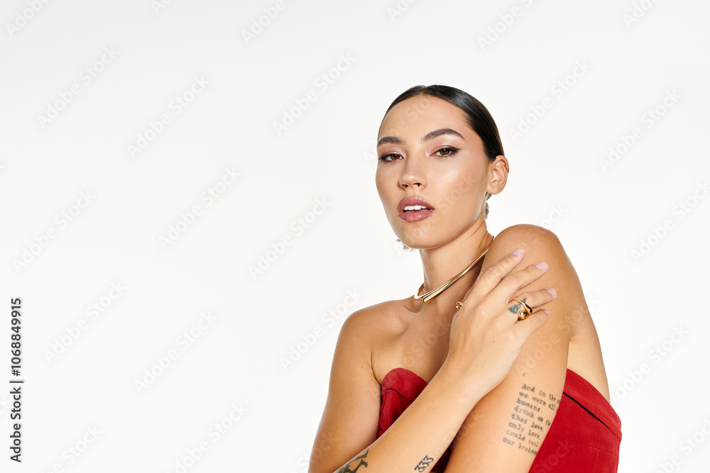 Obraz premium A young woman confidently poses while showcasing her unique style and elegance in red.