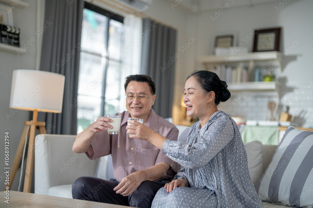 An elderly couple enjoys a peaceful moment at home, sharing smiles and drinks. The warm and cozy atmosphere emphasizes their deep connection, happiness, and the comfort of spending time together. An elderly couple enjoys a peaceful moment at home, sharing smiles and drinks. The warm and cozy atmosphere emphasizes their deep connection, happiness, and the comfort of spending time together.