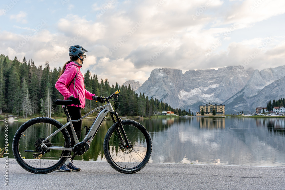 Obraz premium Cycling Adventure: Woman Enjoying the Views at Lake Misurina