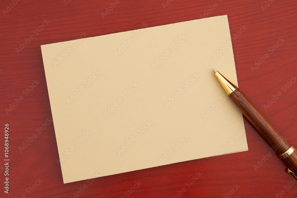 Blank beige greeting card with a pen on a desk