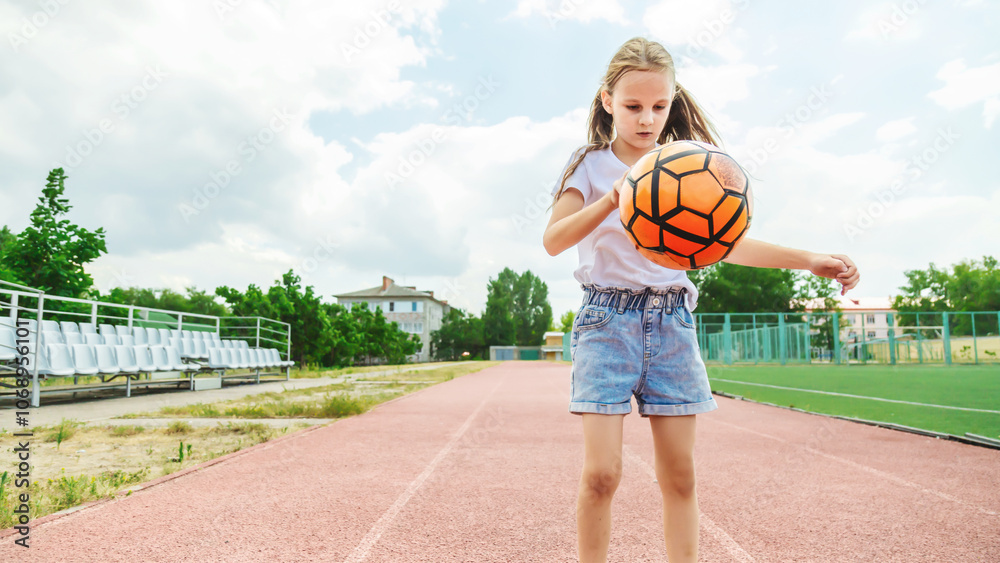 Little girl playing with a soccer ball on outdoor sports fields Little girl playing with a soccer ball on outdoor sports fields