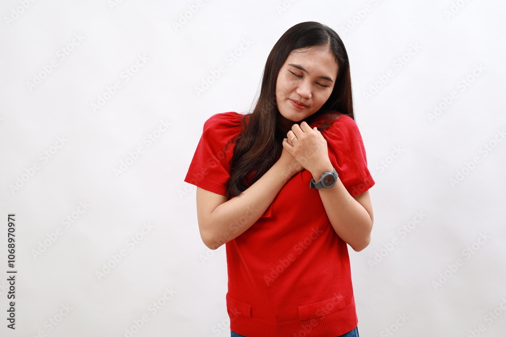 Young woman wearing casual red shirt smiling with hands on chest with closed eyes and grateful gesture on face. health concept. Young woman wearing casual red shirt smiling with hands on chest with closed eyes and grateful gesture on face. health concept.