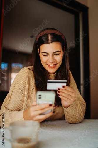 Young caucasian woman buying online on smart phone using credit card 