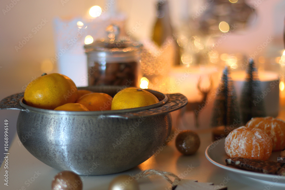 Various Christmas decorations, cookies, chocolate, nuts and tangerines, wine glasses and lit candles on the table. Holiday hygge at home. Selective focus. Various Christmas decorations, cookies, chocolate, nuts and tangerines, wine glasses and lit candles on the table. Holiday hygge at home. Selective focus.