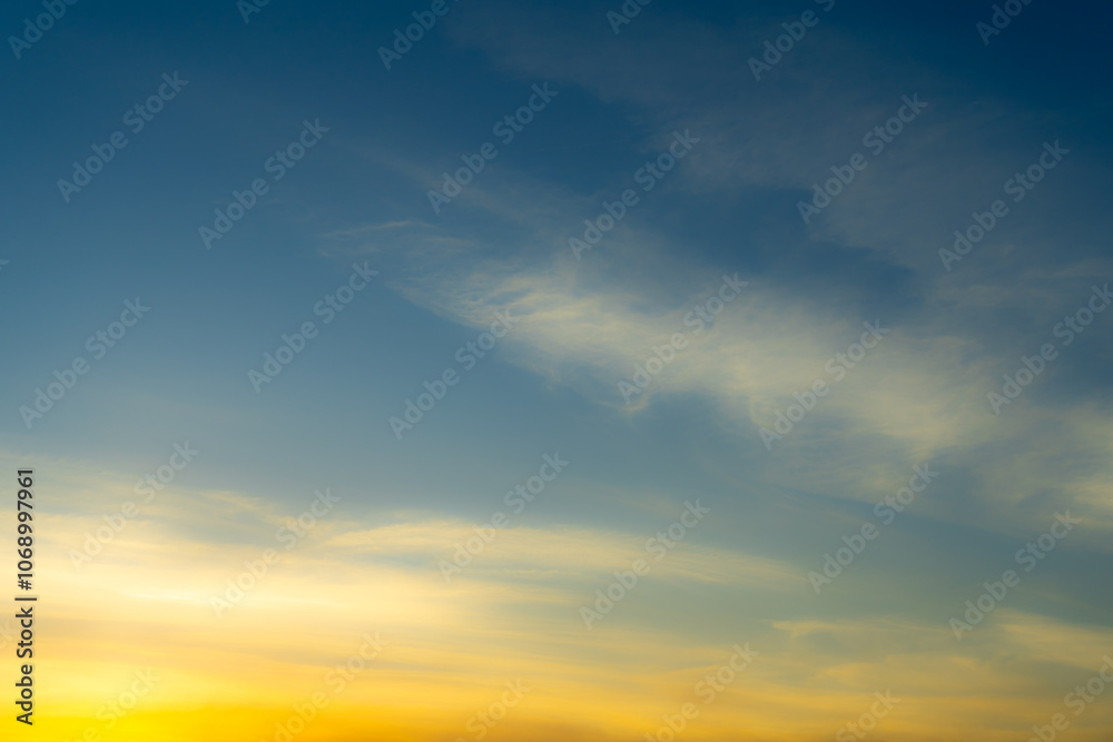 Fototapeta premium Blue and Golden Sky with Colorful Light Pink Cirrus Clouds at Sunset. Wallpaper Texture Background.