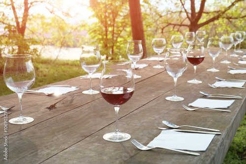 Wine glasses on a wooden table in the countryside