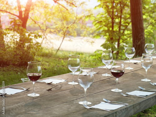 wine glasses on a wooden table in the countryside photo